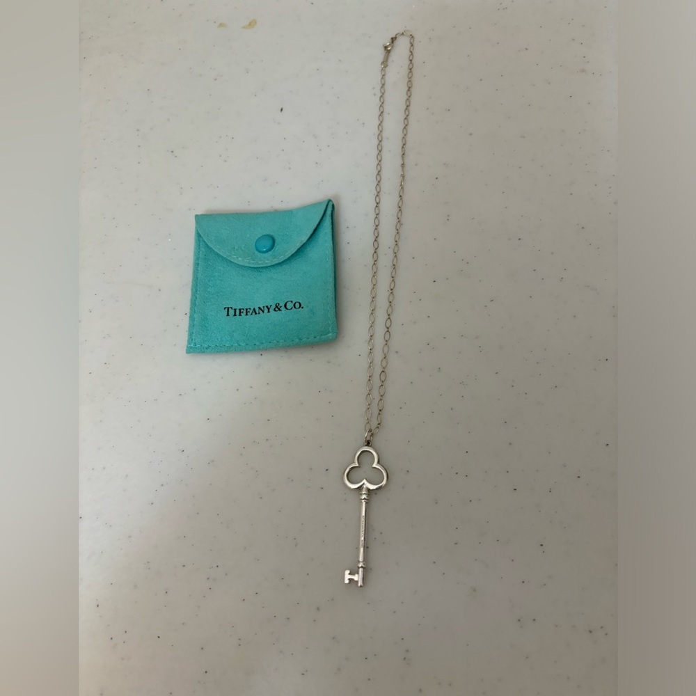 Tiffany & Co Sterling silver clover key charm necklace. 18 inch chain with bag.
